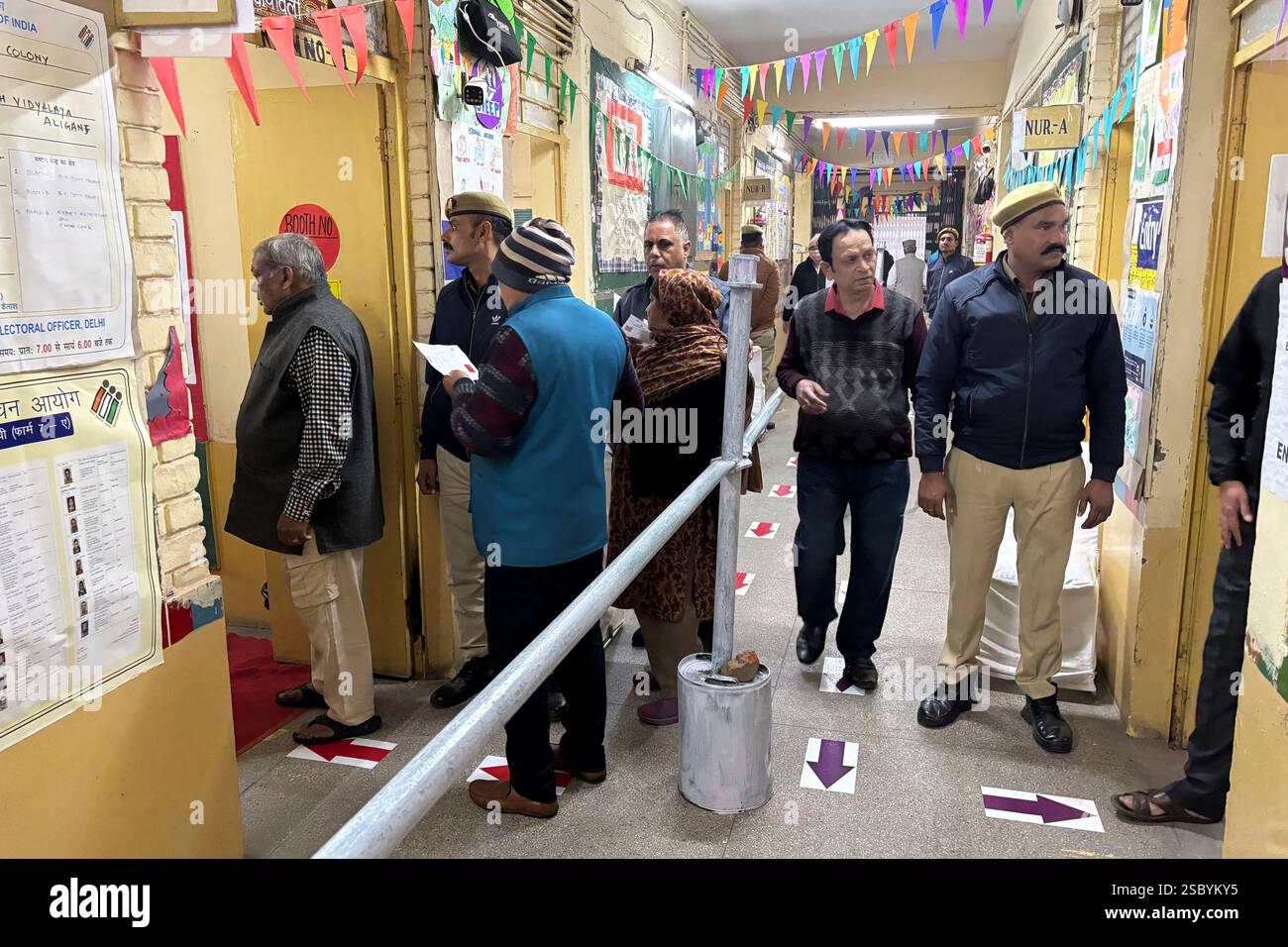People stand in a queue to cast their votes for the capital’s state ...