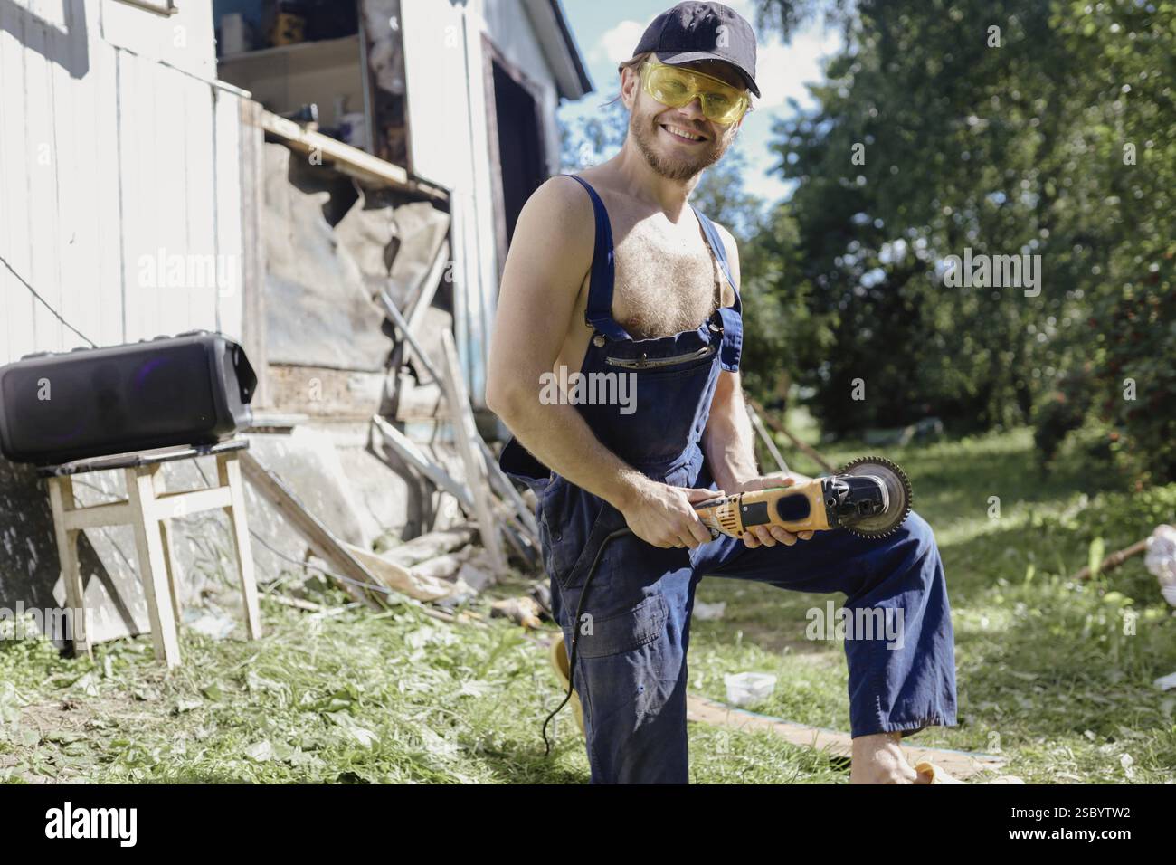 Smiling individual holding a tool in an outdoor work setting Stock ...