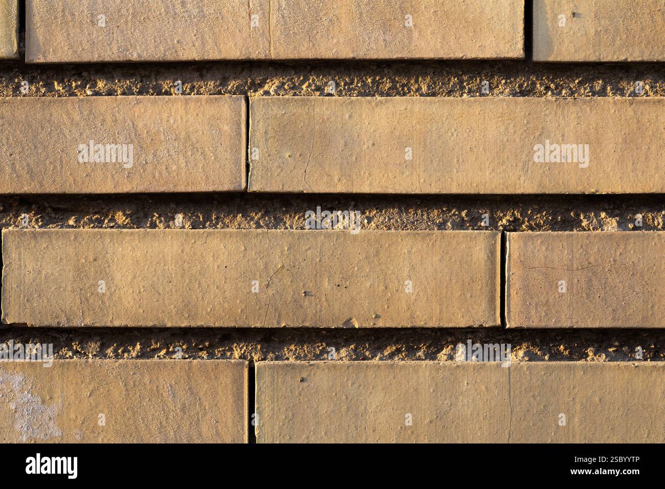 Light colored brick wall with sunset light, form an irregular background texture Stock Photo