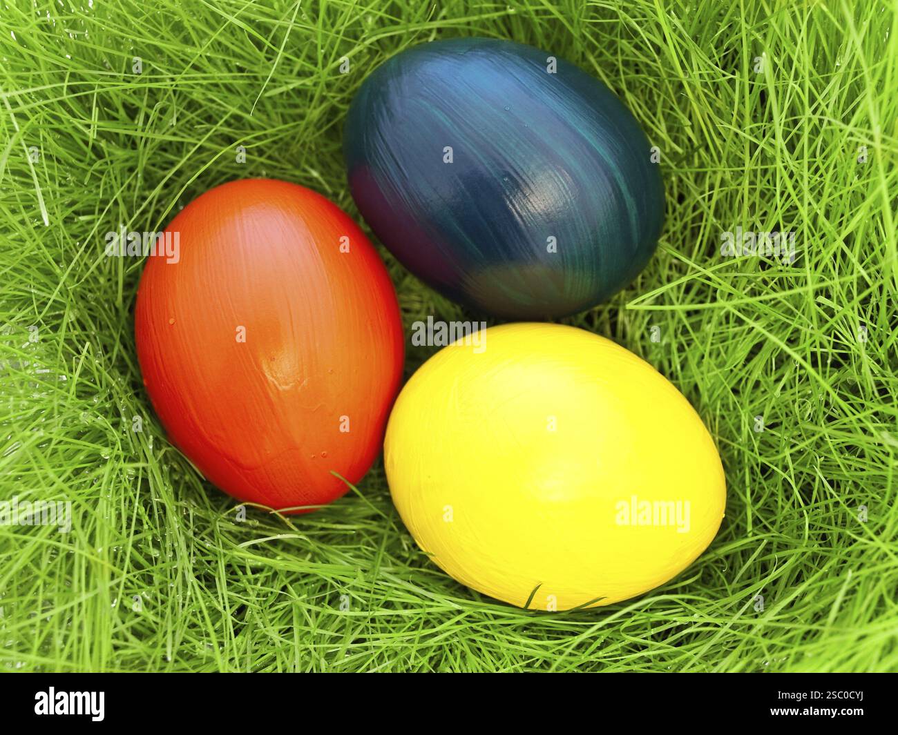 Three Multicolored Eastern Eggs In Fresh Green Grass Stock Photo