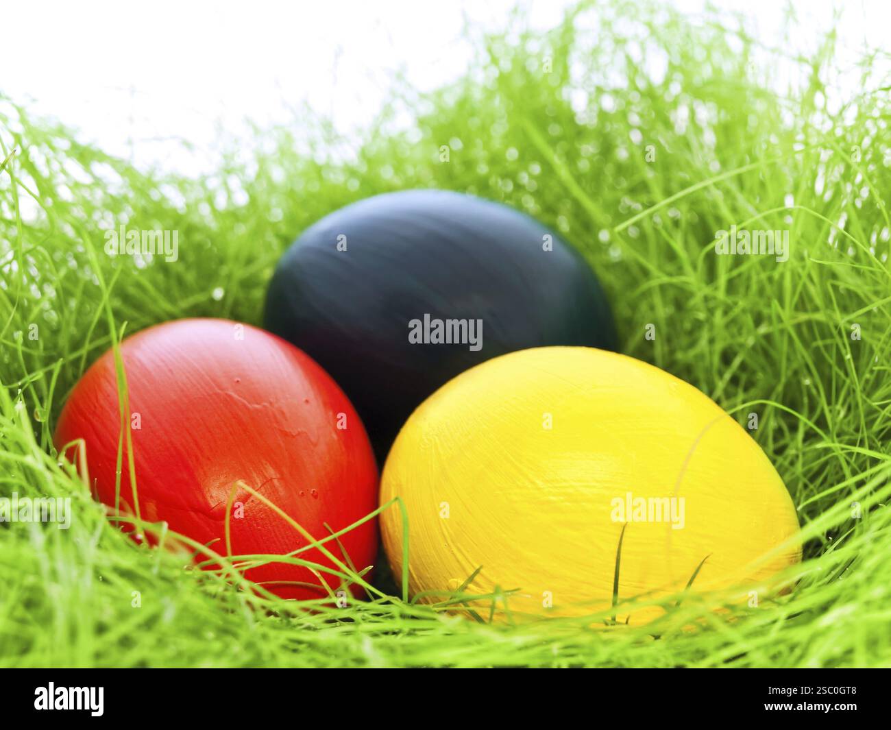 Three Multicolored Eastern Eggs In Fresh Green Grass Stock Photo