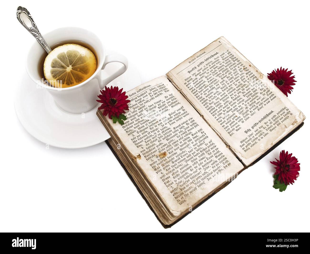 Cup of tea near the open old book with red flowers Stock Photo - Alamy