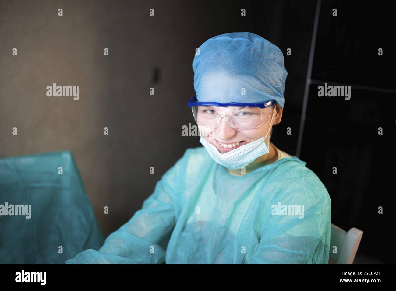 A smiling medical professional in blue protective clothing Stock Photo