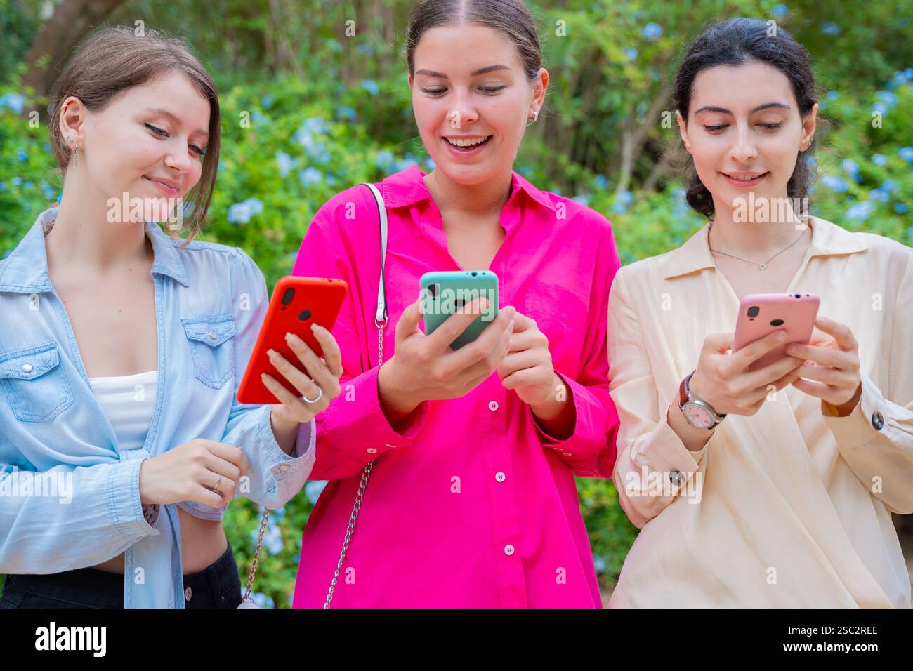 Happy Young Women Using Smartphones Outdoors Stock Photo