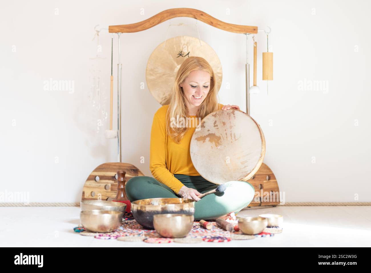 Young cheerful woman performing music therapy session with traditional ...