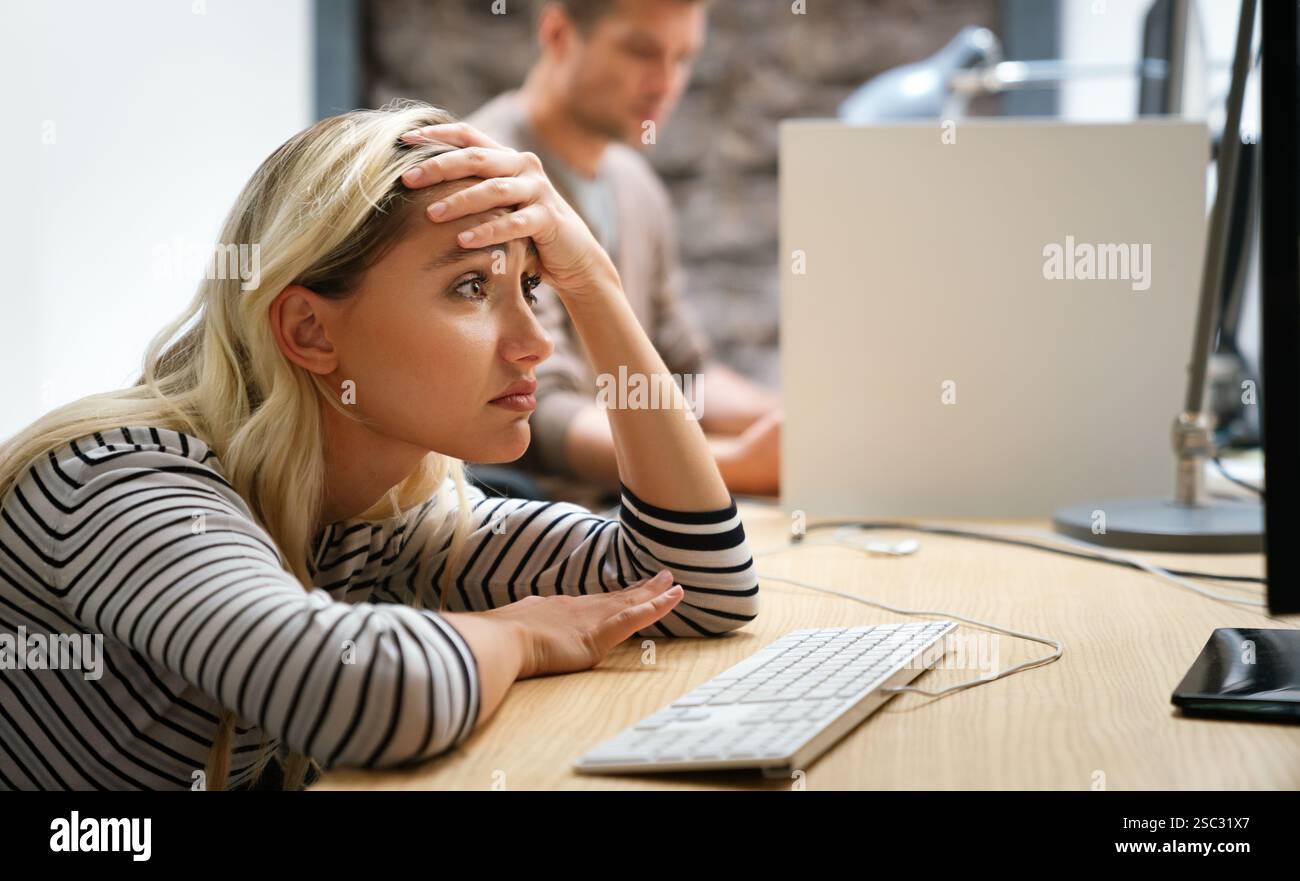 Portrait of a disappointed woman programmer looking stressed out while working on a computer code Stock Photo