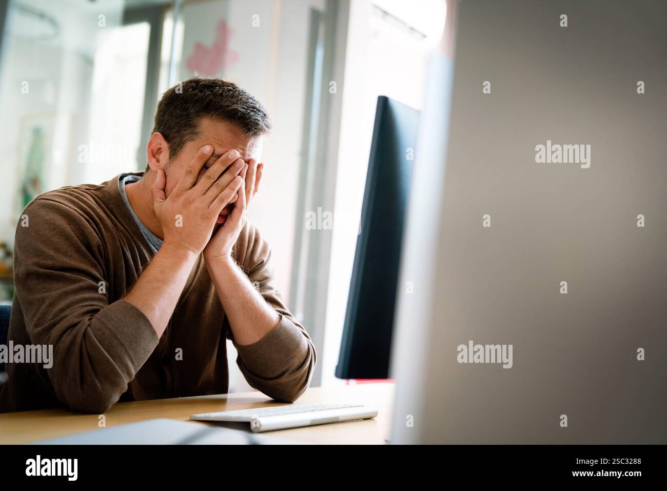 Portrait of a disappointed man programmer looking stressed out while working on a computer code Stock Photo