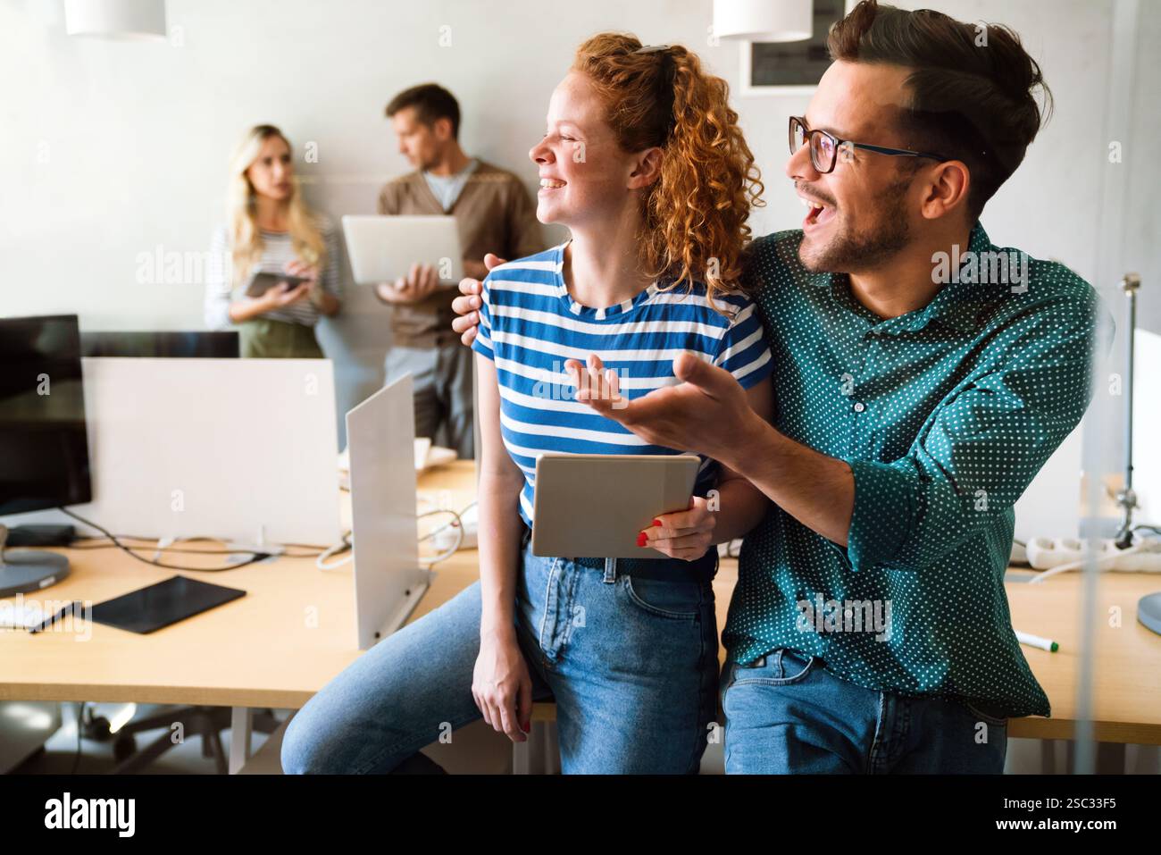 Two young businesspeople using a digital tablet while standing in a boardroom. Stock Photo