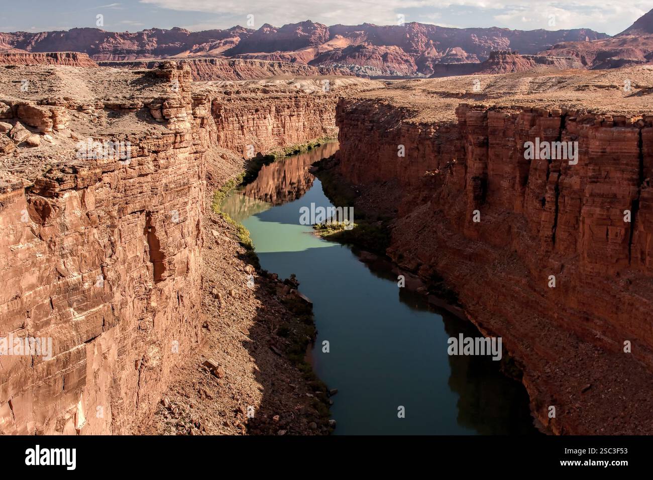 A river runs through a canyon with a rocky shoreline. The water is ...