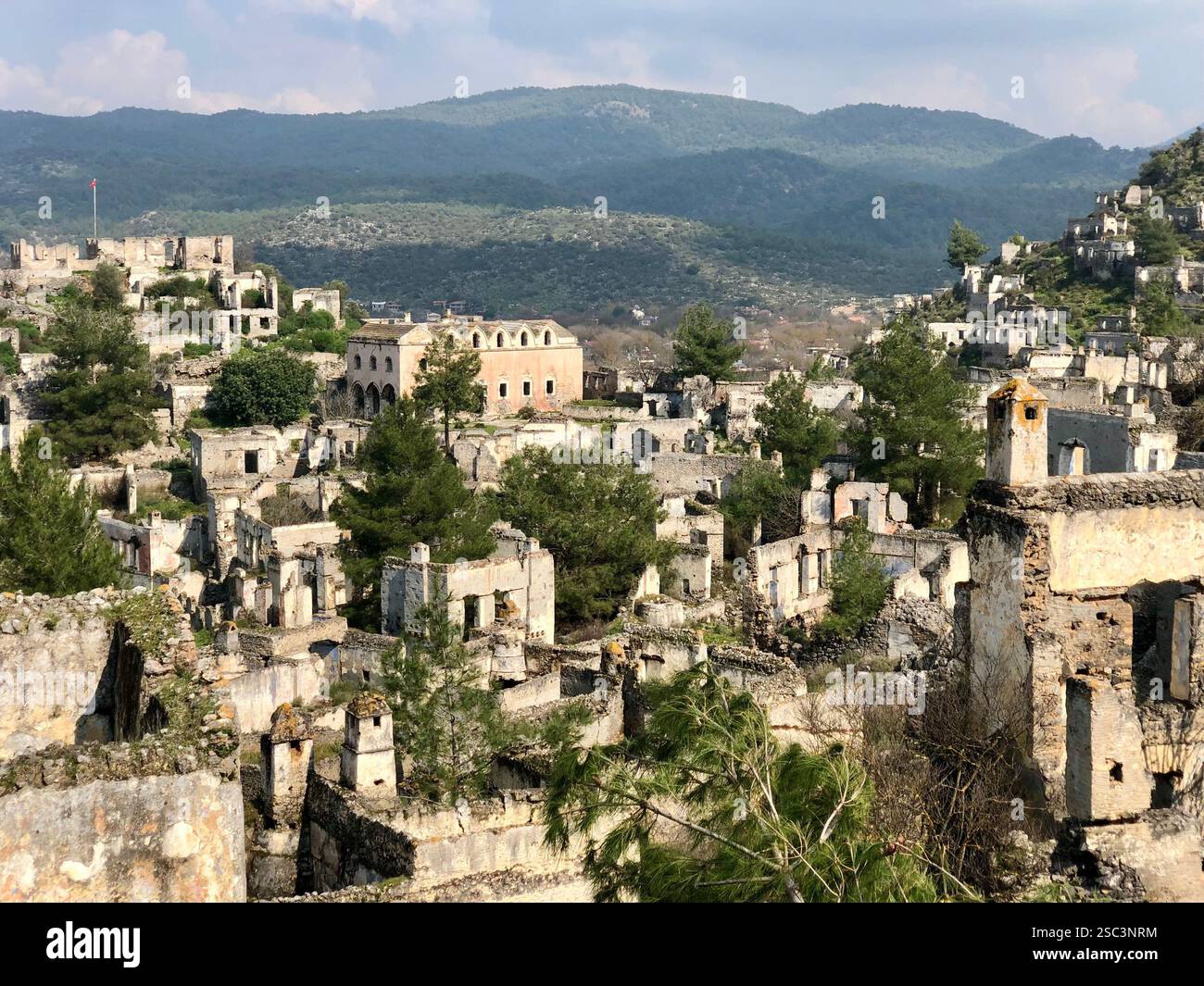 An abandoned ghost village in the hills of Turkey surrounded by mountains and trees - Smartphone Captured Stock Image