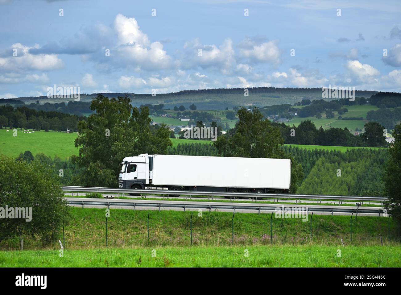Truck drives through Ardennes landscape Stock Photo