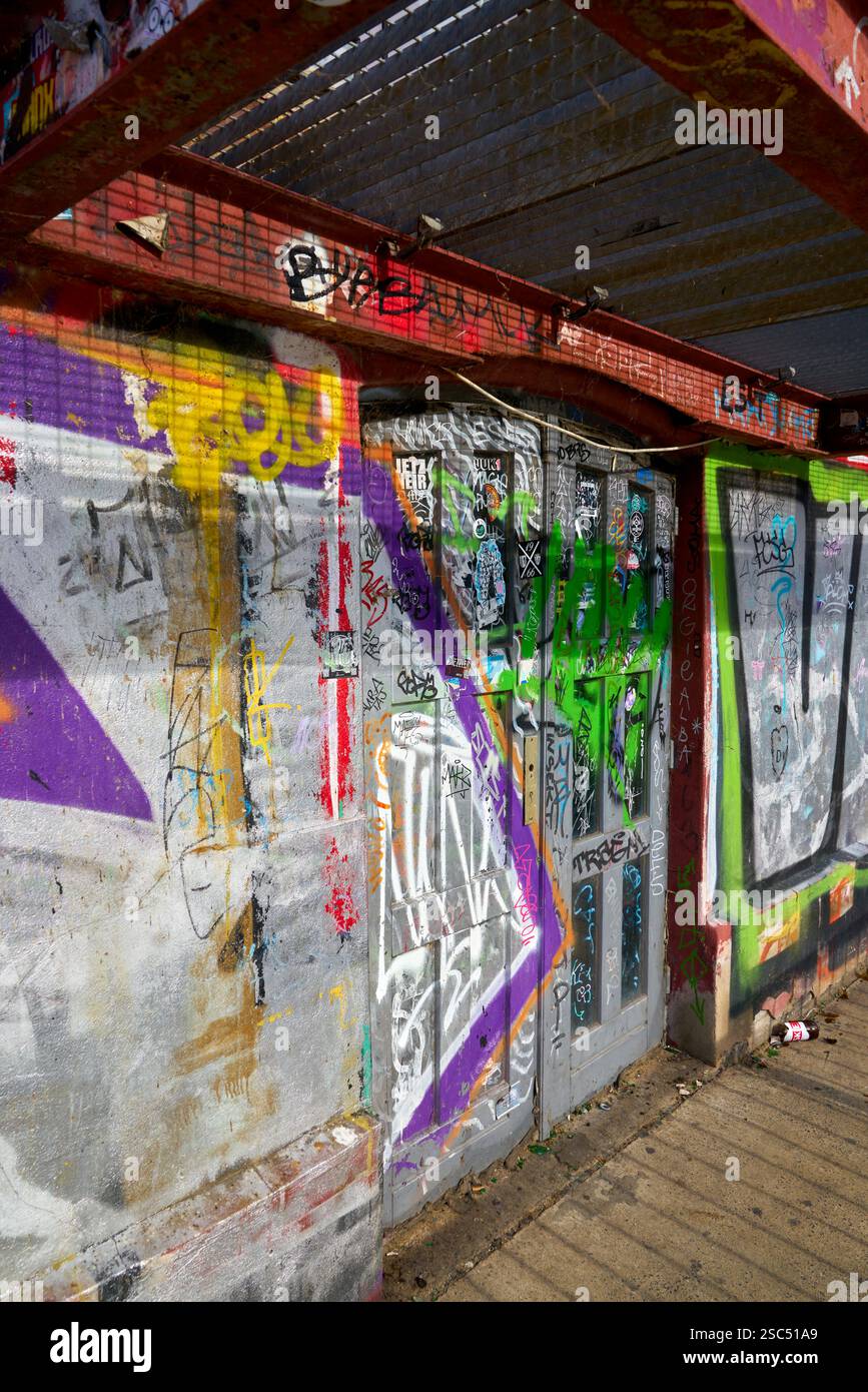 Graffiti and Tags on Alley Door. Colorful graffiti on an alley wall and old door. Stock Photo