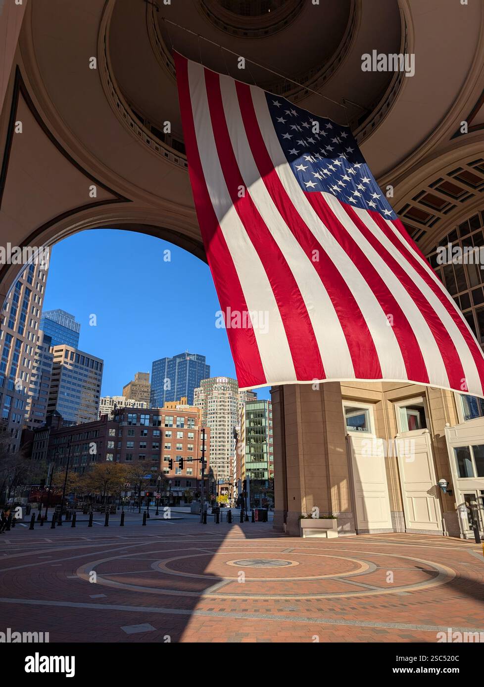 Large USA flag hanging in arch, Boston Harbor hotel, Rowes wharf, Boston, Massachusetts, USA - Smartphone Captured Stock Image