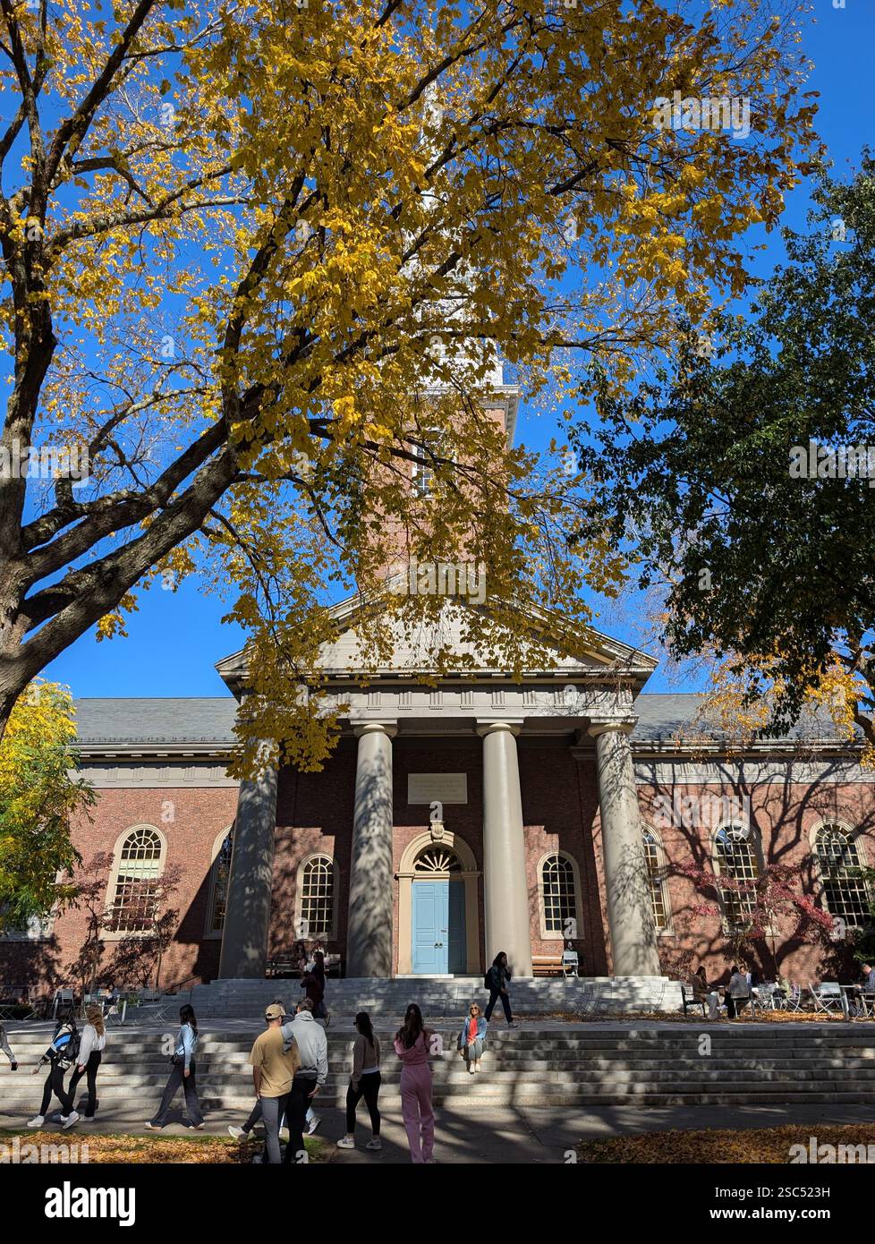 The Memorial Church of Harvard University is a building on the campus of Harvard University, with the steeple of the building, set against Blue Sky. - Smartphone Captured Stock Image