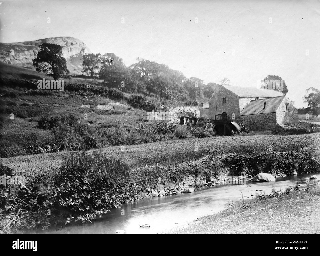 A farmhouse beside a stream at the foot of a mountain. Llandudno, Wales ...
