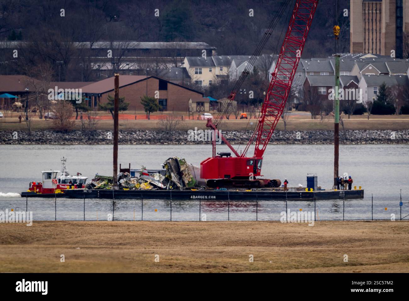 A salvage vessel carrying wreckage moves from the site in the Potomac ...