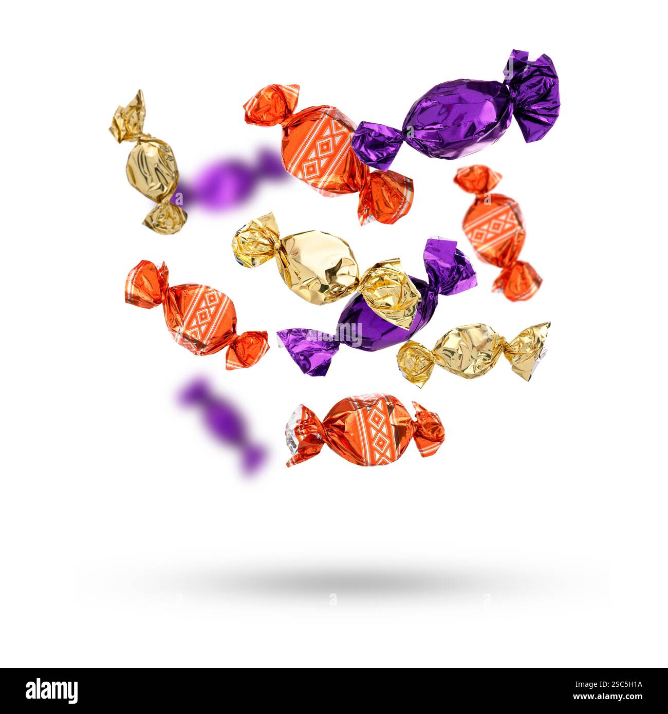 Candies in bright wrappers falling on white background Stock Photo