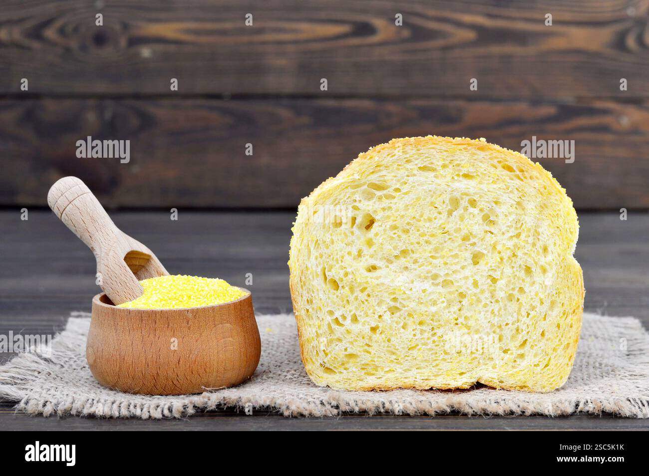 Sliced corn bread and corn flour in wooden bowl Stock Photo