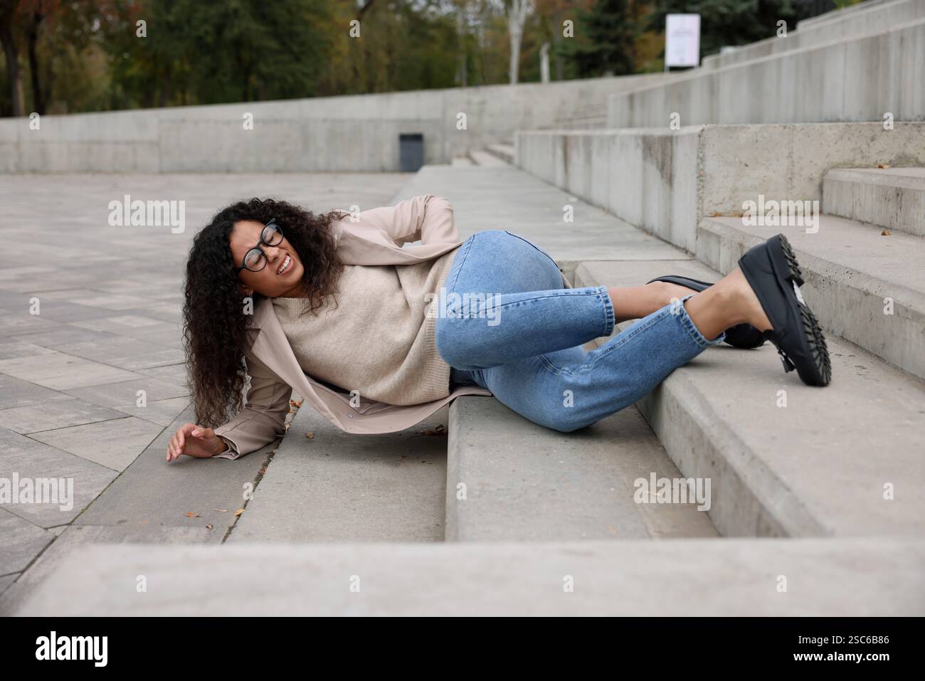 Injured woman on stairs outdoors after fall. Dangerous accident Stock ...