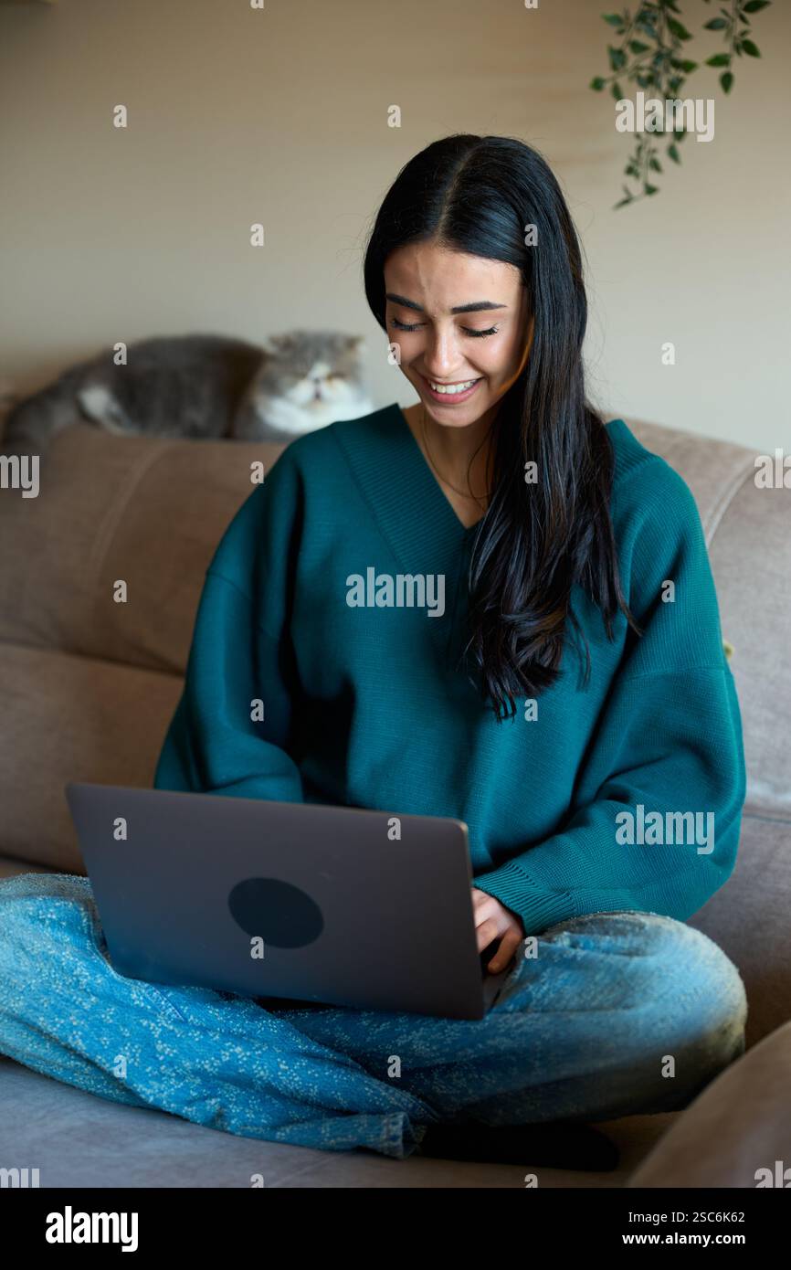 Smiling freelancer working from home with pet cat Stock Photo