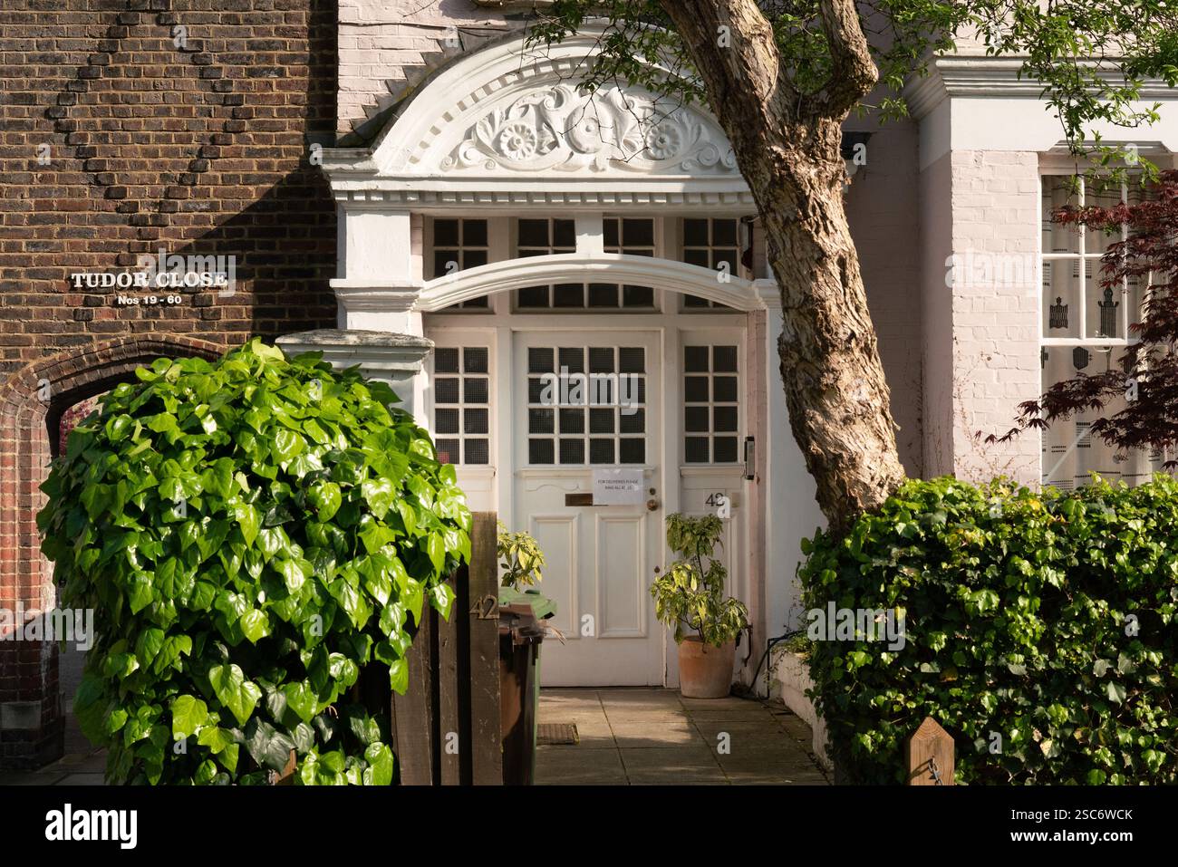 Tudor Close, London, UK.  No. 42,  a house with a white door and arched entryway. Stock Photo
