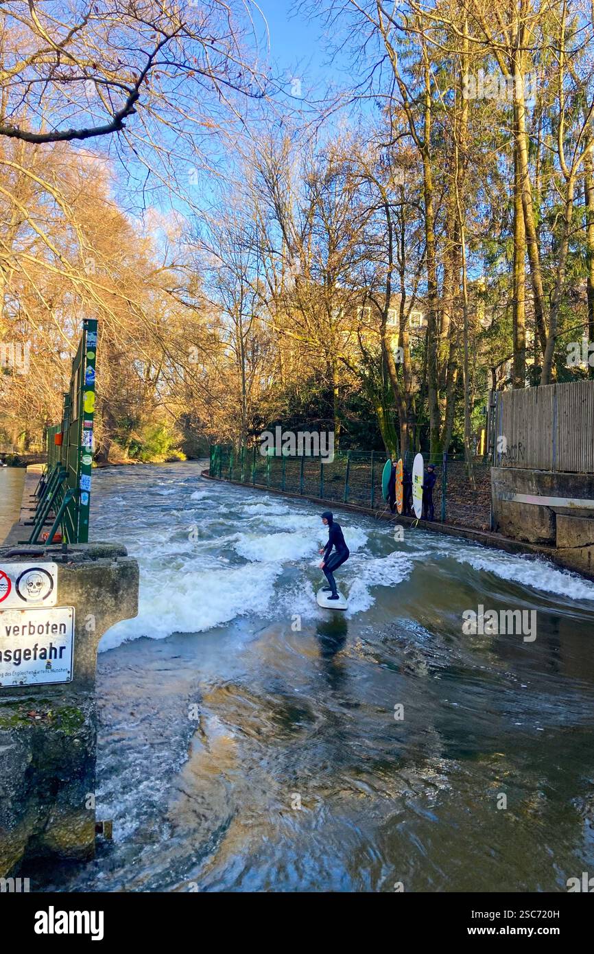 MUNICH, GERMANY - DECEMBER 2, 2024: Surfers on Eisbach river in the English garden in Munich, Bavaria - Smartphone Captured Stock Image