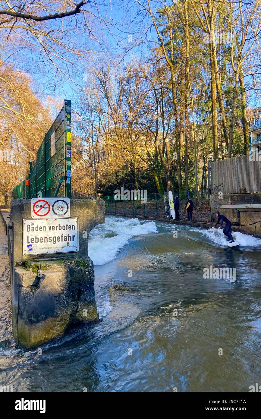 MUNICH, GERMANY - DECEMBER 2, 2024: Surfers on Eisbach river in the English garden in Munich, Bavaria - Smartphone Captured Stock Image