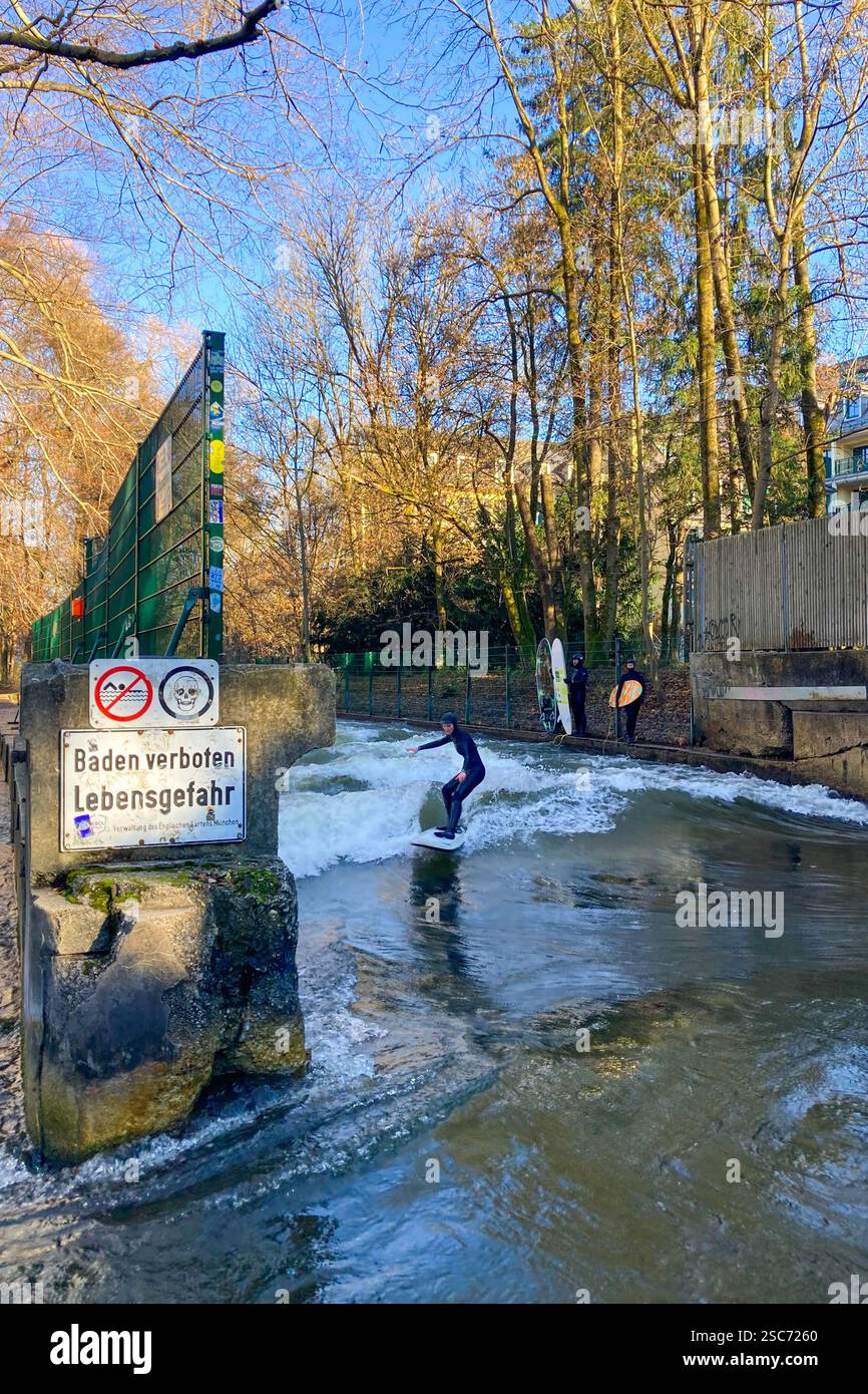 MUNICH, GERMANY - DECEMBER 2, 2024: Surfers on Eisbach river in the English garden in Munich, Bavaria - Smartphone Captured Stock Image