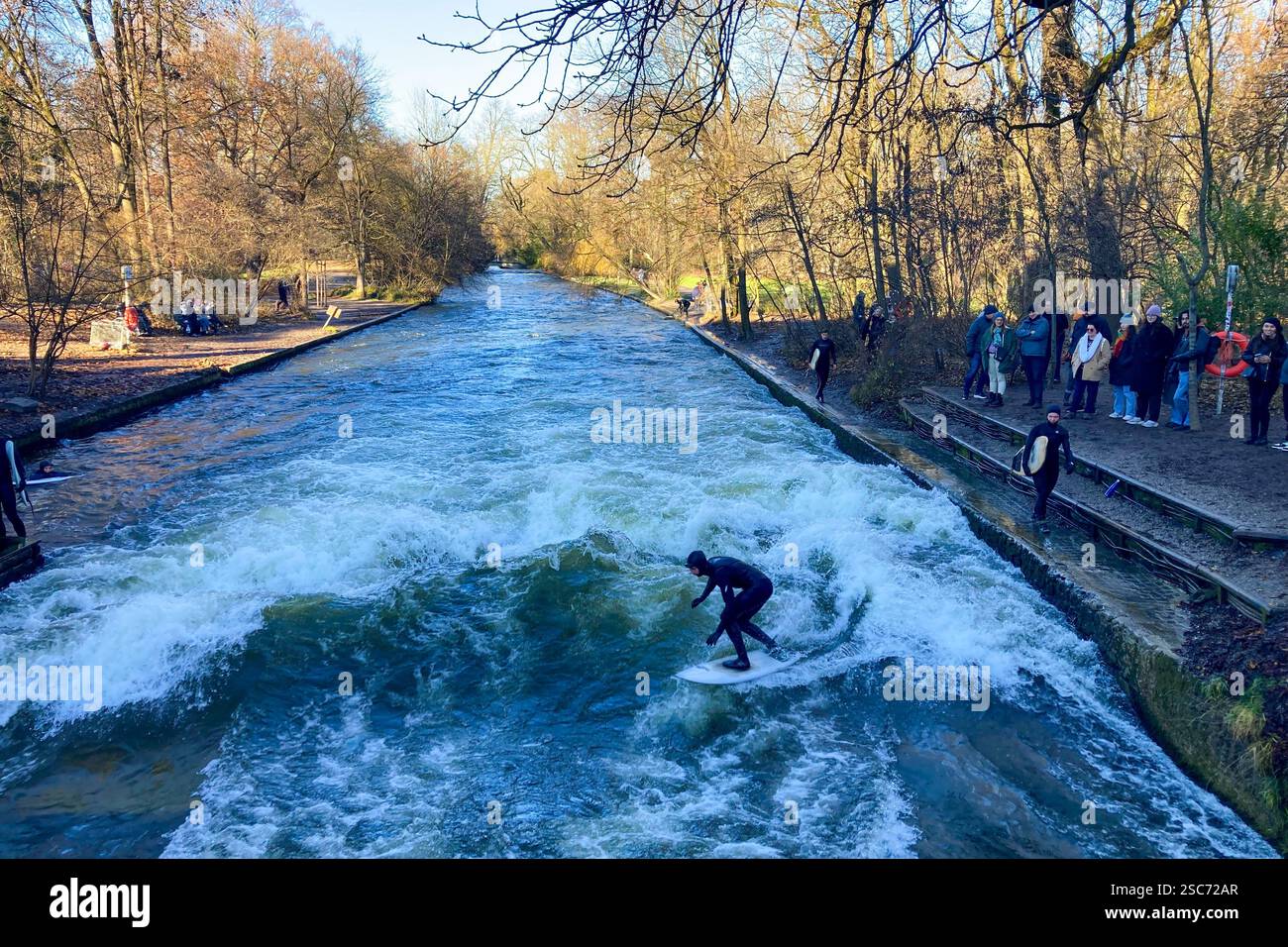 MUNICH, GERMANY - DECEMBER 2, 2024: Surfers on Eisbach river in the English garden in Munich, Bavaria - Smartphone Captured Stock Image