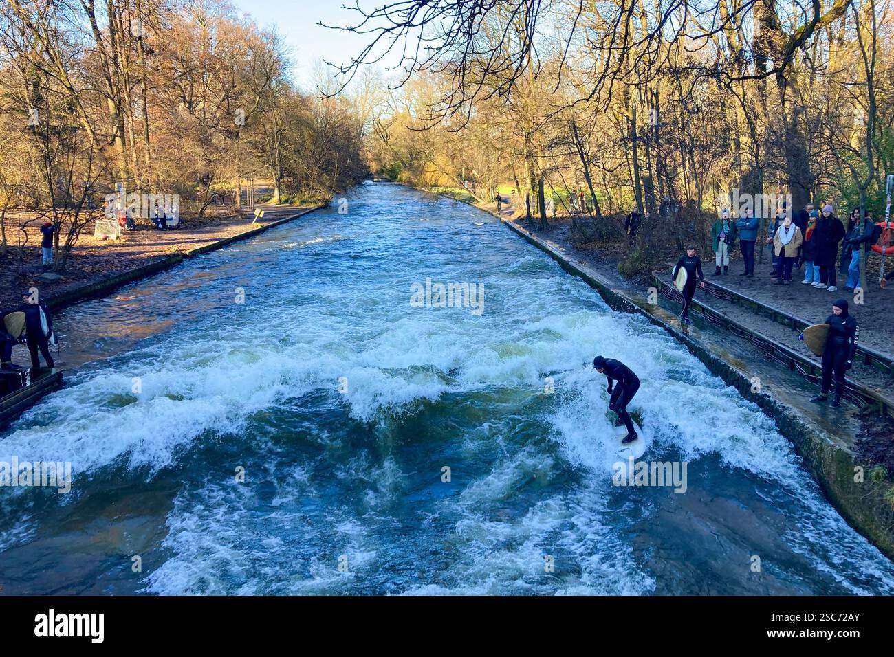 MUNICH, GERMANY - DECEMBER 2, 2024: Surfers on Eisbach river in the English garden in Munich, Bavaria - Smartphone Captured Stock Image