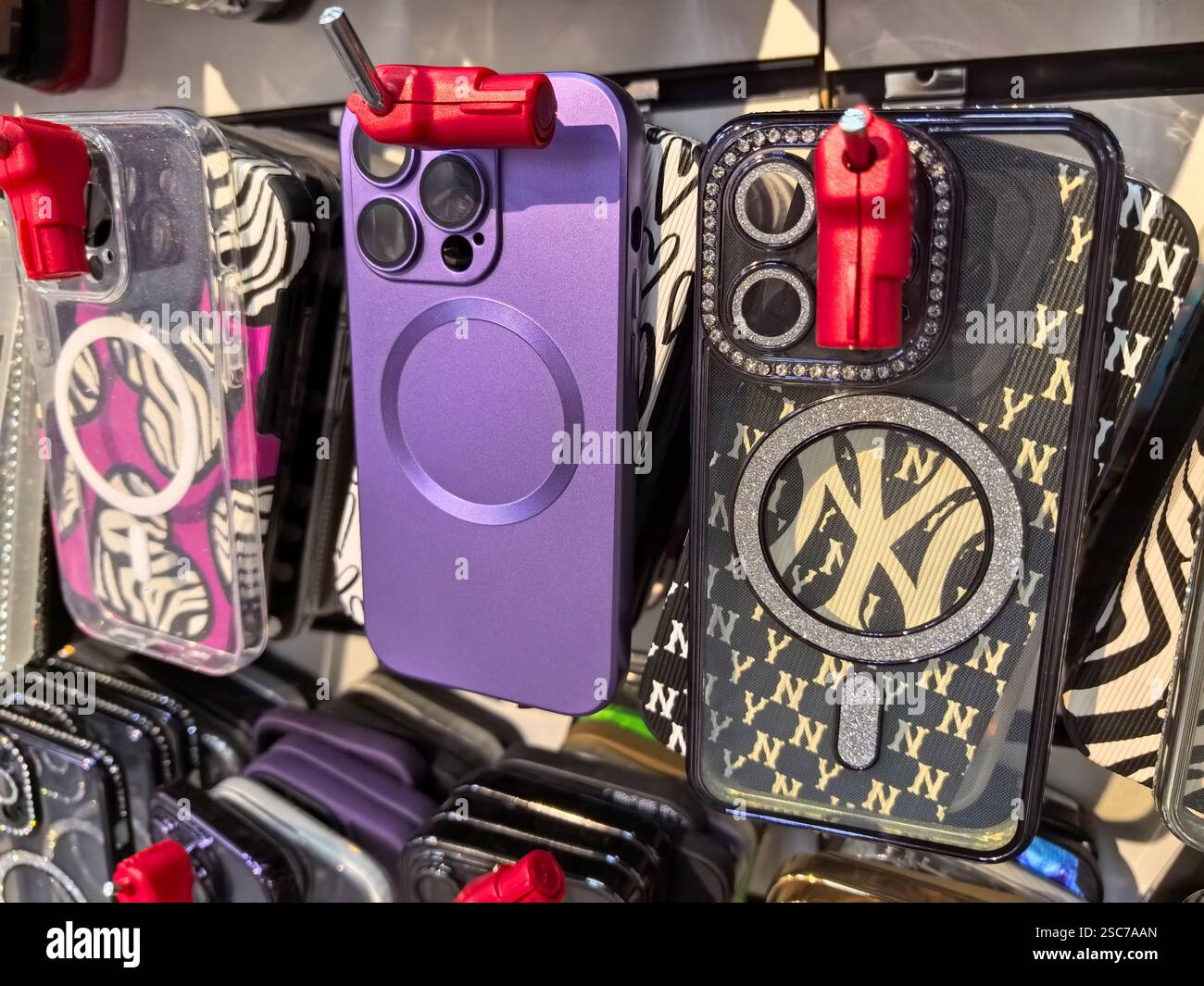 Bobruisk, Belarus - 2 February 2025: Colorful phone cases hang on display in a lively market. Unique designs feature patterns and textures, showcasing Stock Photo