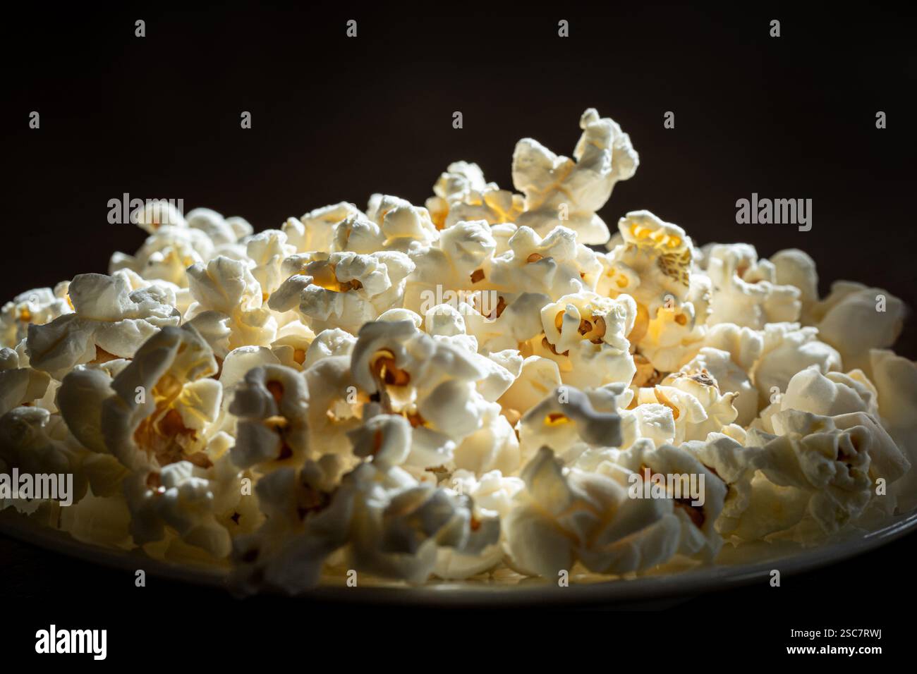 Close-up of freshly popped popcorn on black background Stock Photo