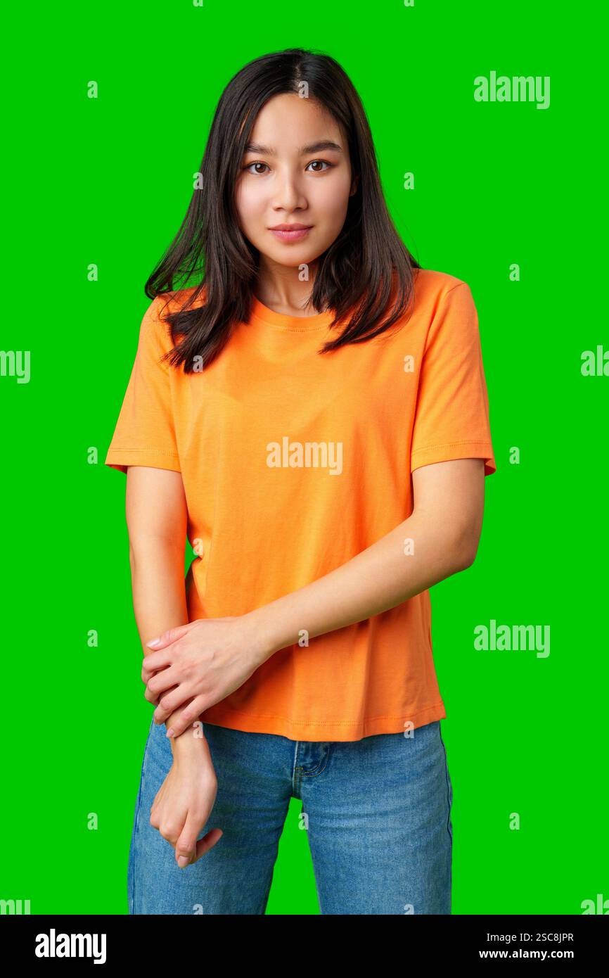 Young woman wearing an orange shirt poses confidently against a vibrant ...