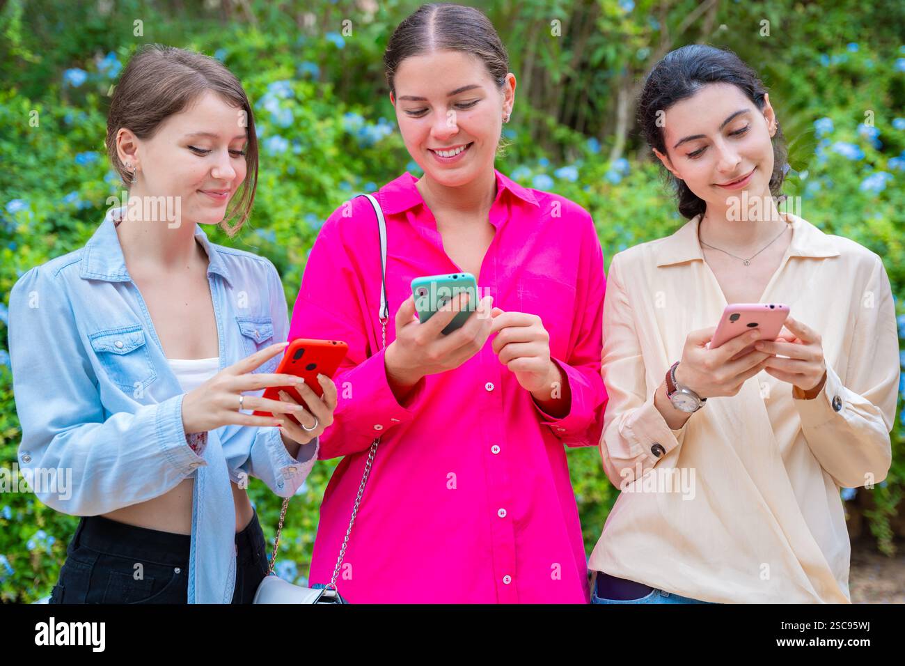 Happy Young Women Using Smartphones Outdoors Stock Photo