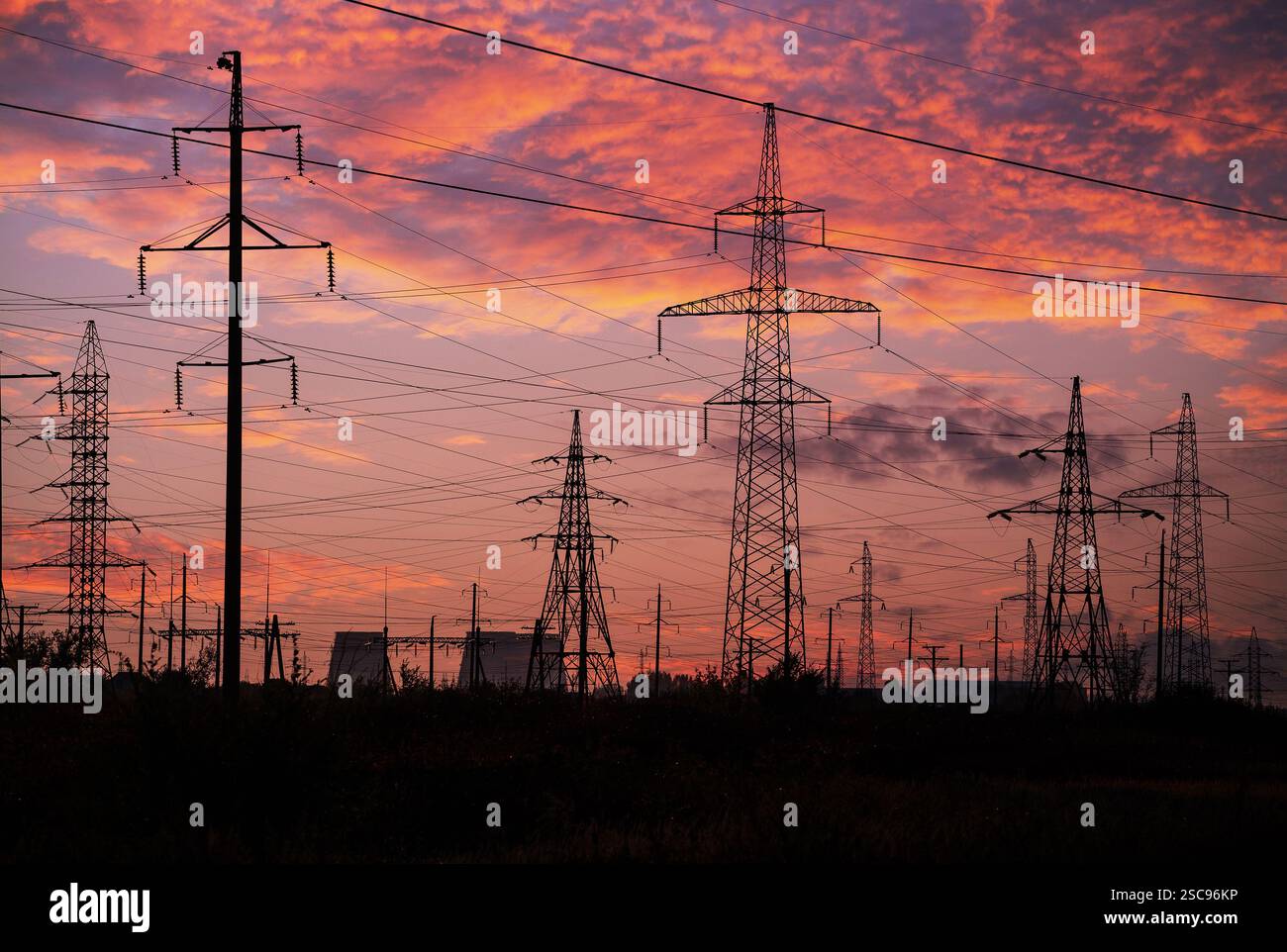 High-voltage power transmission towers in sunset sky background Stock ...