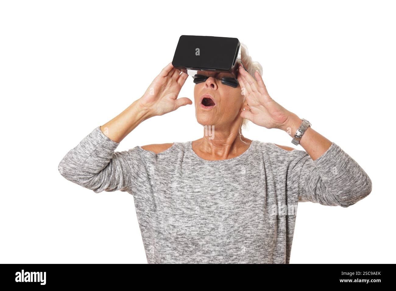 Elderly woman amazed while using a vr headset Stock Photo