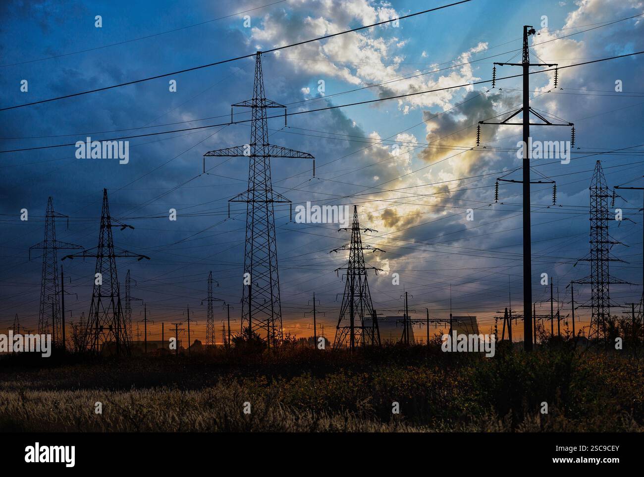 High-voltage power transmission towers in sunset sky background Stock ...