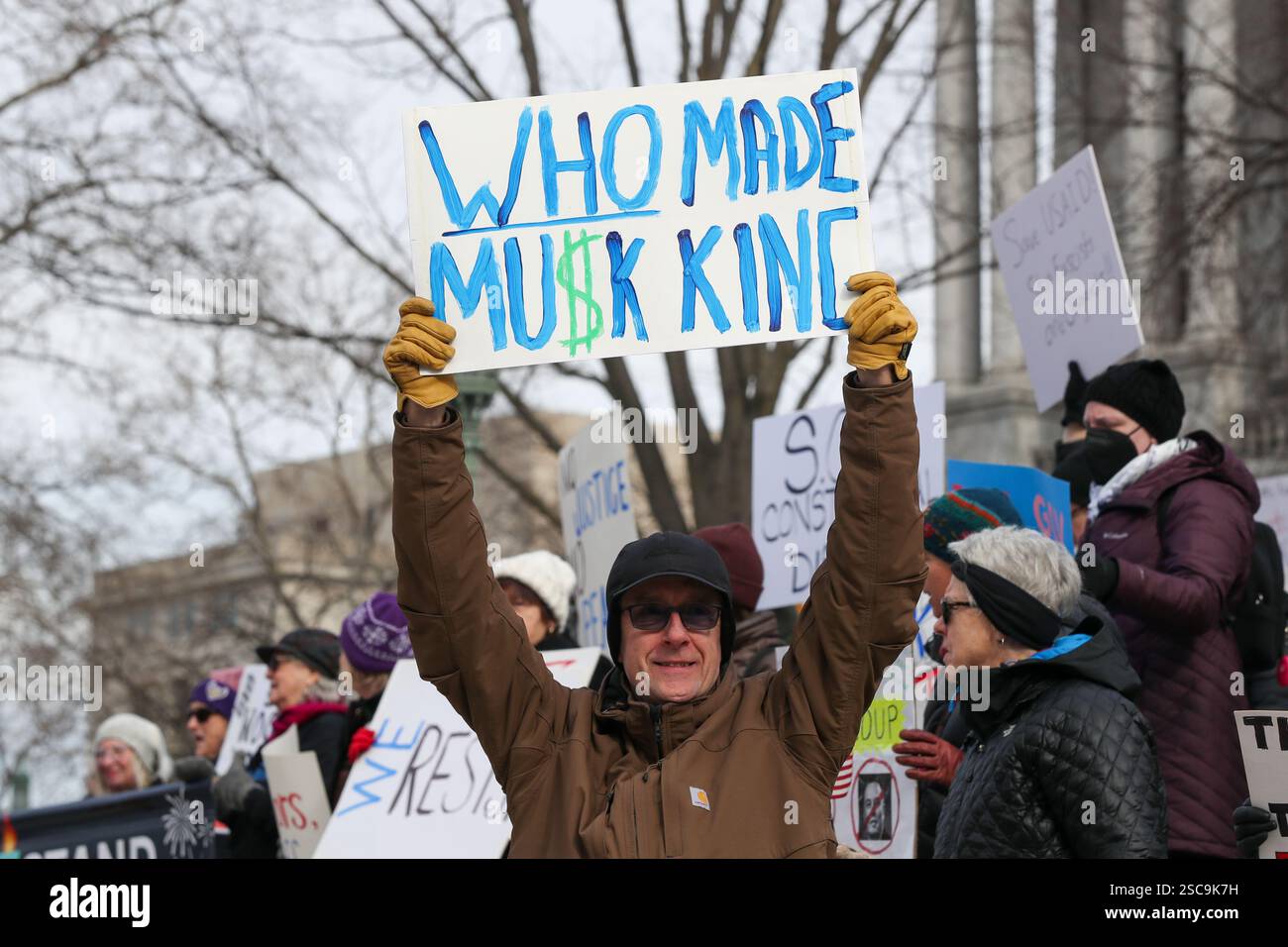 Protesters hold placards during a 50501 protest outside of the