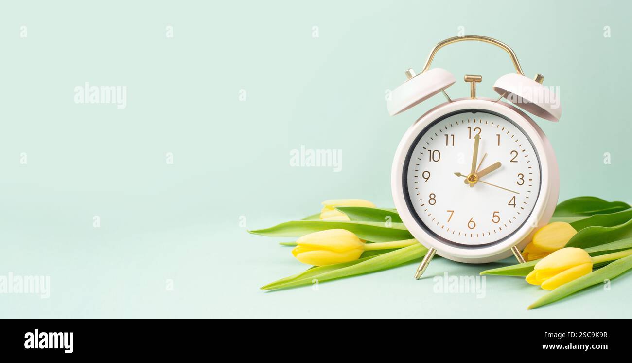 Alarm clock with yellow tulip flowers, switch to daylight saving time ...