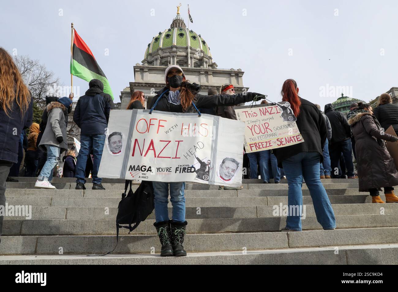 A protester holds a placard outside of the Pennsylvania Capitol during