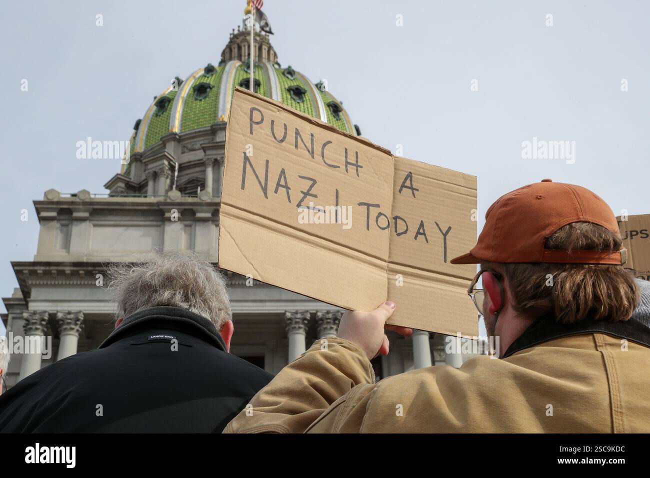 A protester holds a placard outside of the Pennsylvania Capitol during