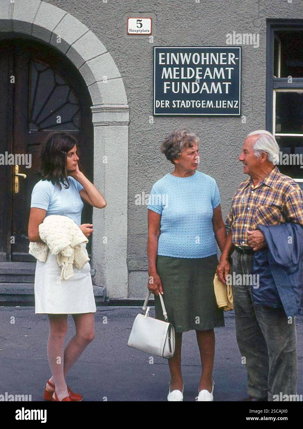 A family is standing in front of the residents' registration office and lost property office of the municipality of Lienz. [automated translation] Stock Photo