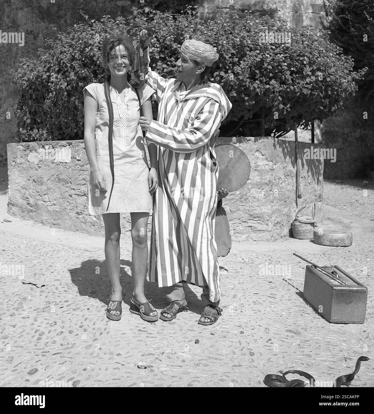 Woman with snake around her neck and a snake charmer in Tangier. Stock Photo