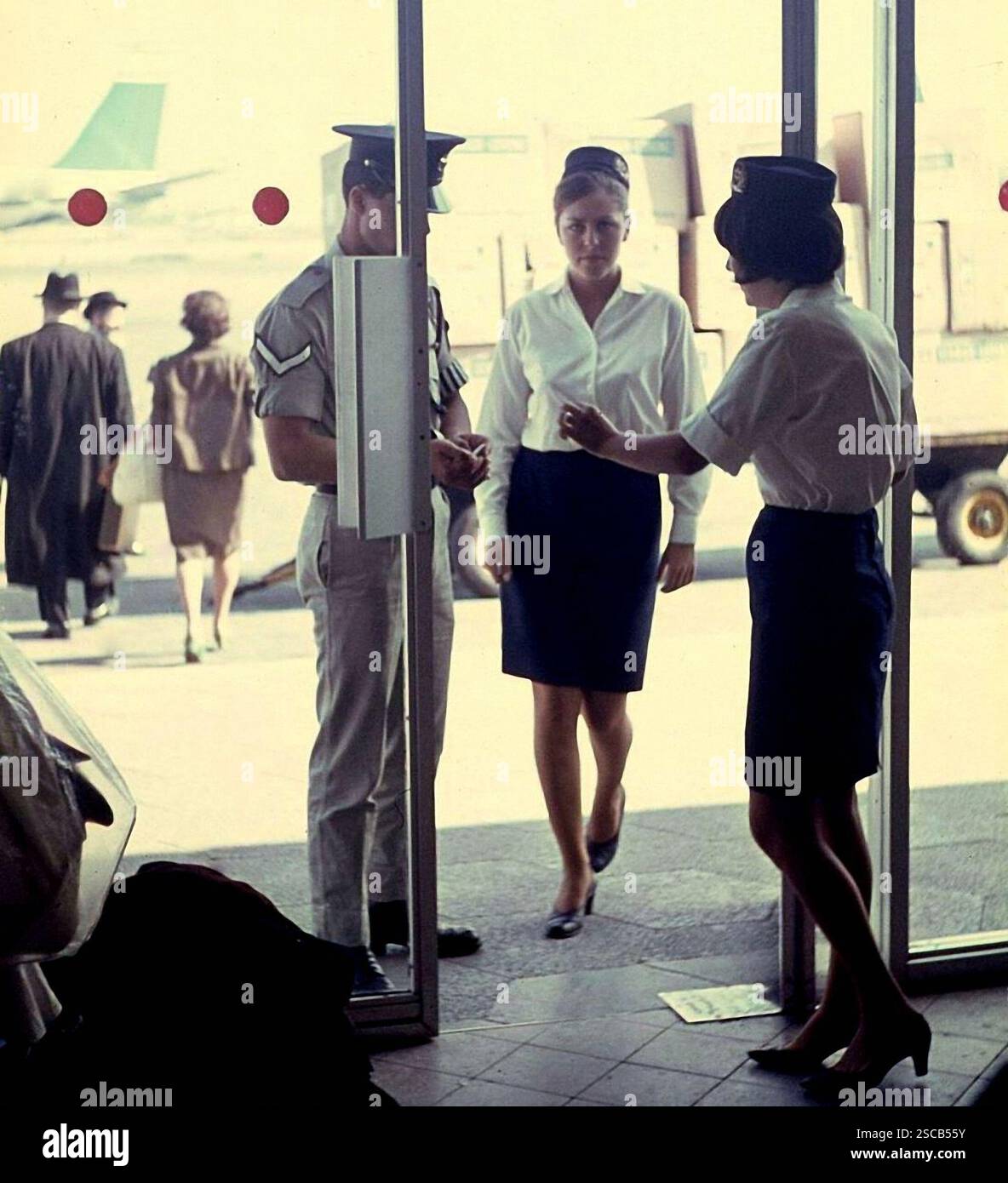 A customs officer and two flight attendants at the entrance of the Lod Airport. Stock Photo