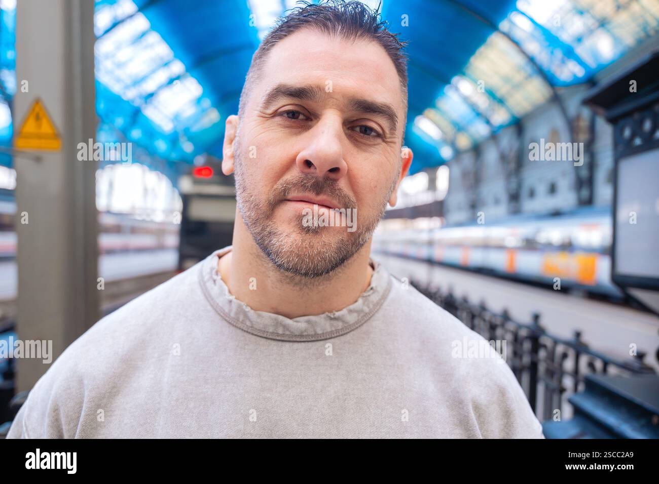Thoughtful Man Looking Up at Train Station looking at camera Stock Photo