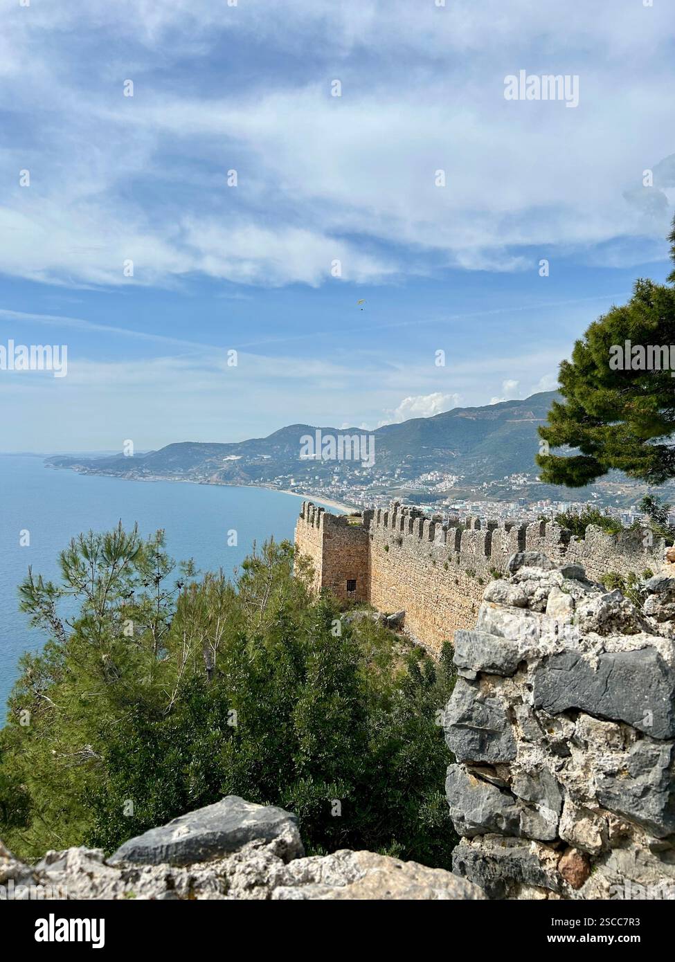 Beautiful scenic view of the sea, mountains and a castle wall - Smartphone Captured Stock Image