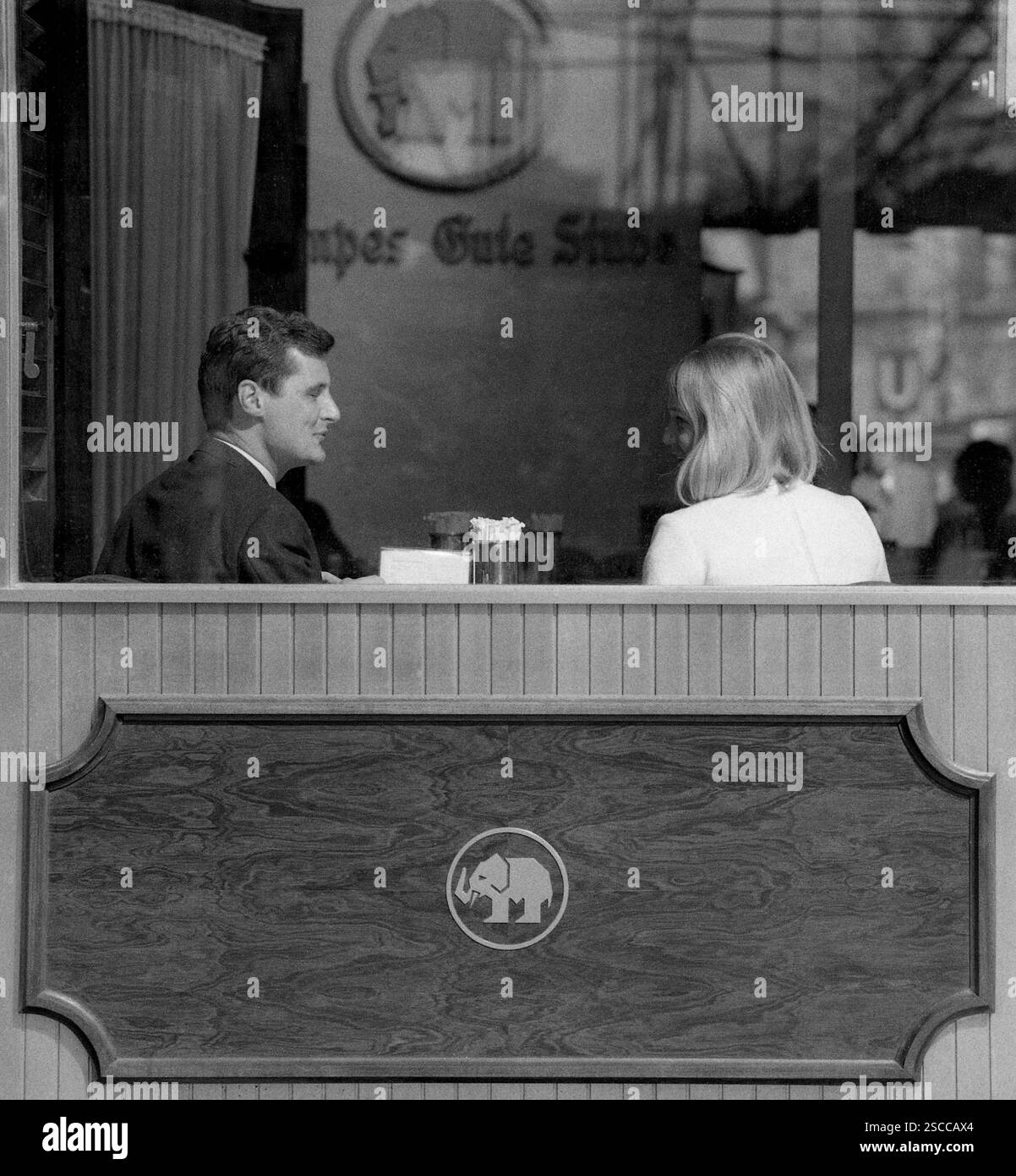 Mampes Gute Stube at the Kurfuerstendamm in Berlin. Picture shows a couple through the window, the man laughing. Stock Photo