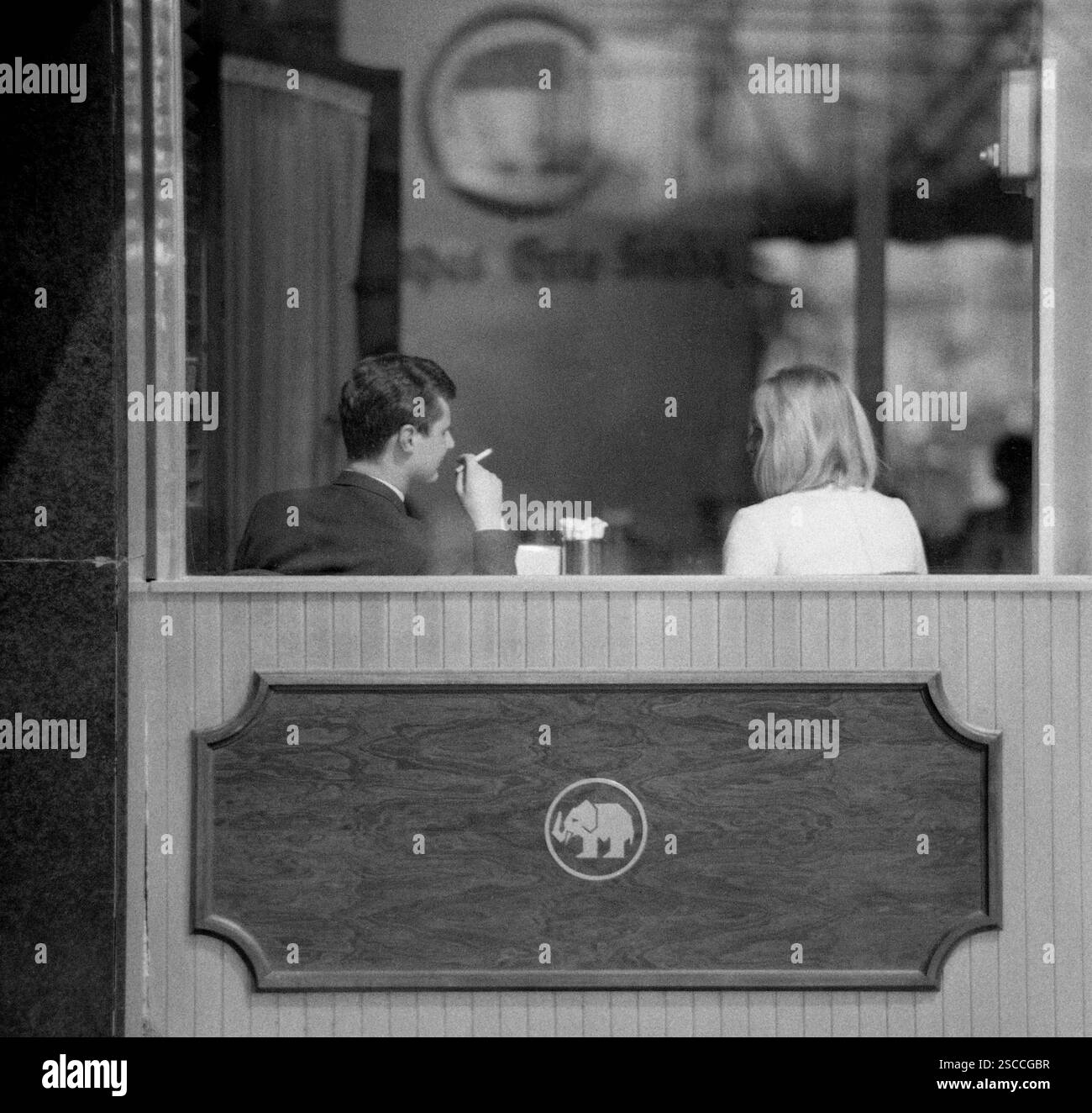 Mampes Gute Stube at the Kurfuerstendamm in Berlin. Picture shows a couple through the window, the man smoking. Stock Photo