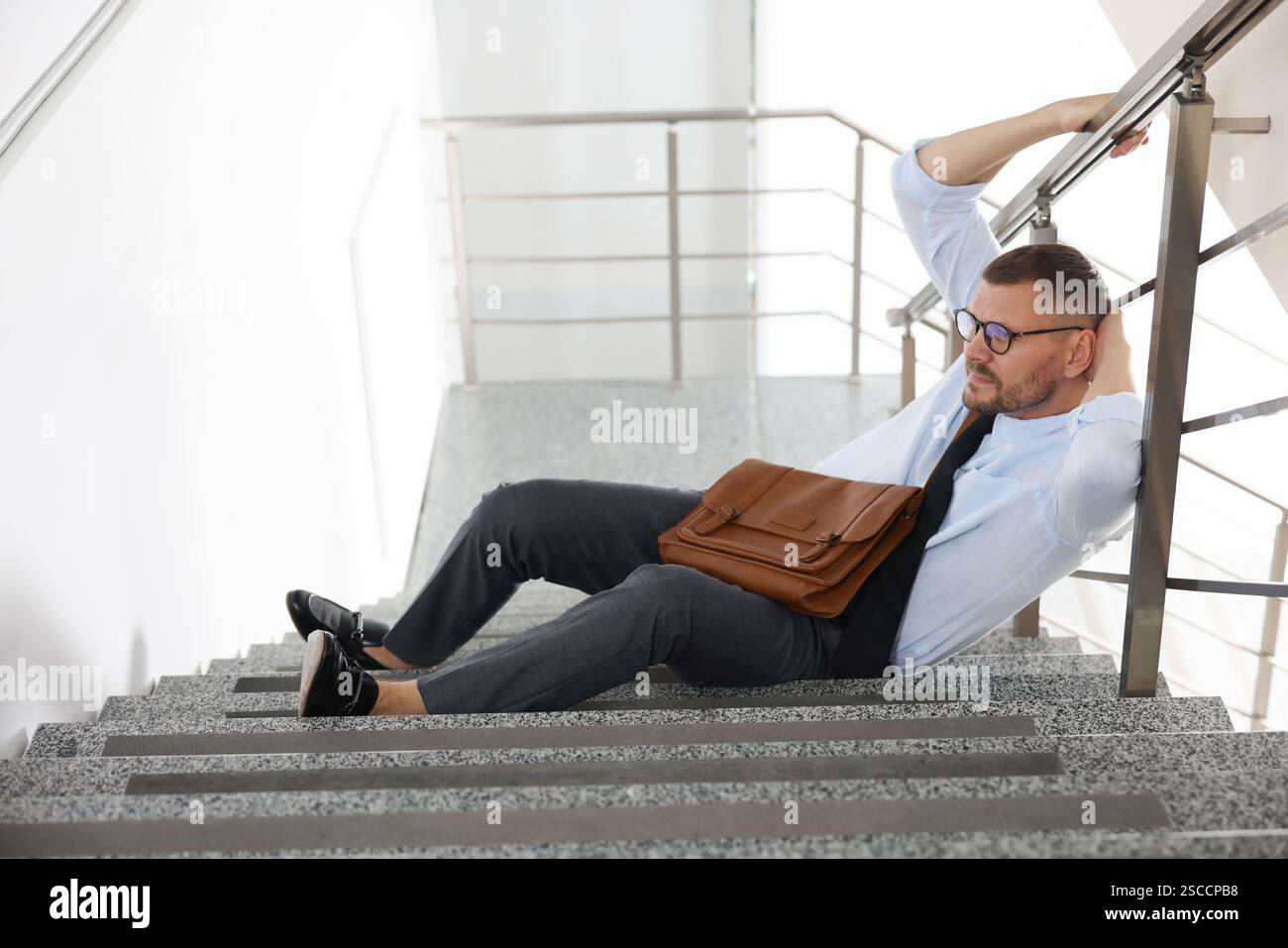 Man with injured head on stairs in building after fall. Dangerous ...