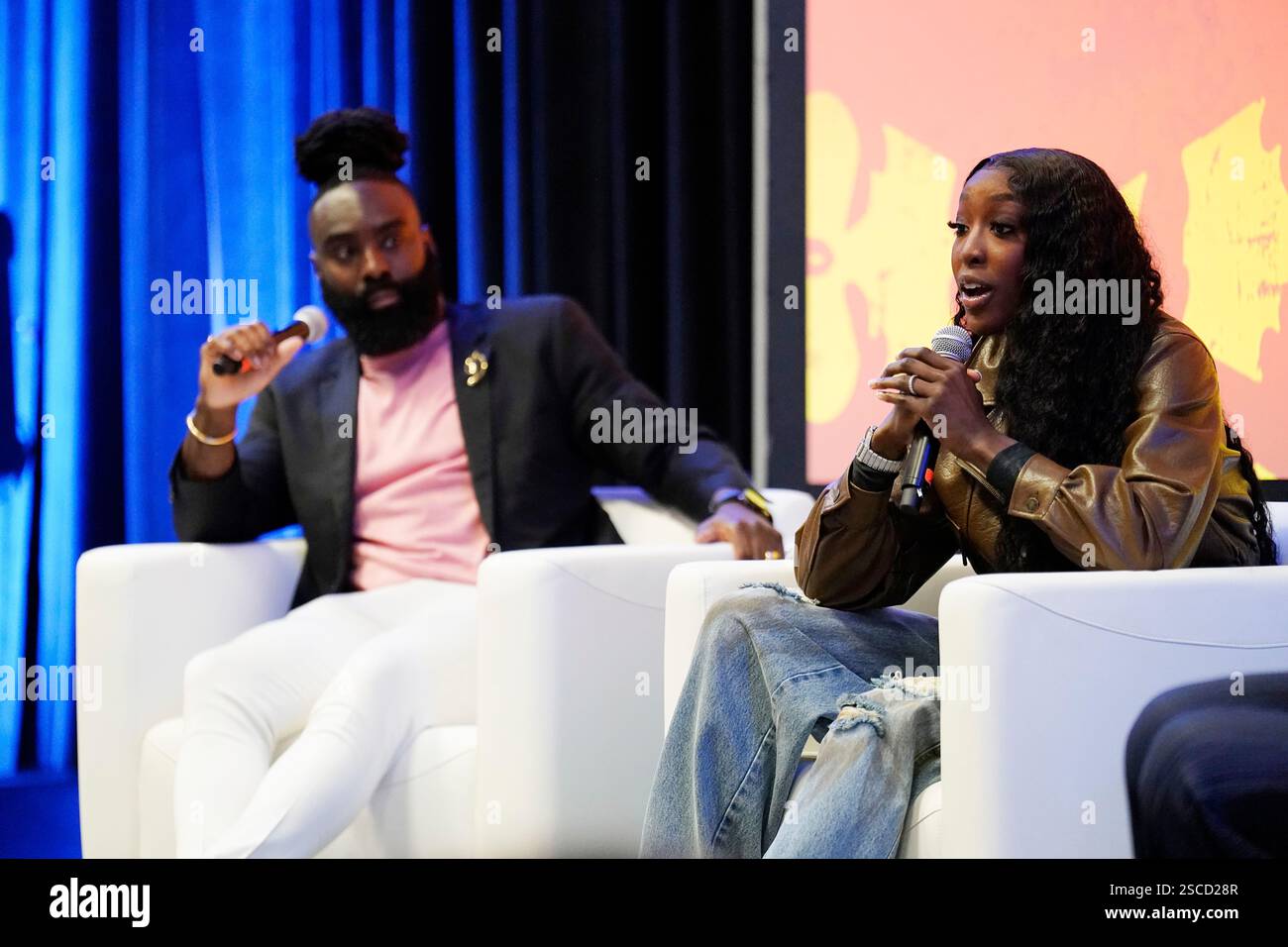 Flau'Jae, right, speaks on stage at the Intuit For Education x NFL